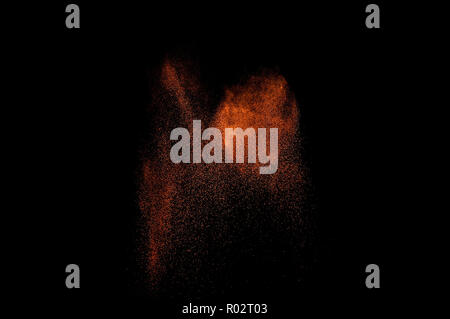 Orange powder explosion on black background. Colored powder cloud. Colorful dust explode. Paint Holi. Stock Photo