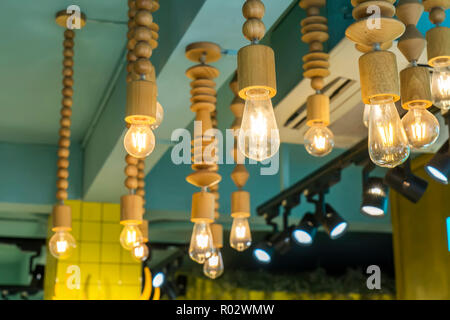 Decorative vintage edison light bulbs against striped wooden wall background. Retro lighting decor. Stock Photo