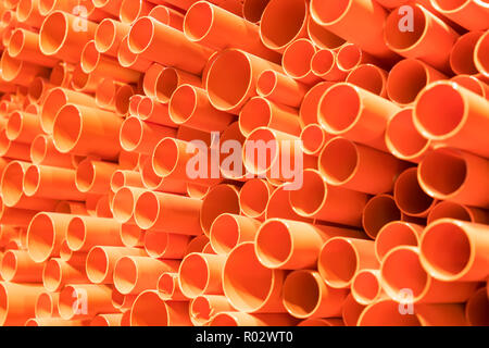 orange PVC pipes stacked in construction site Stock Photo