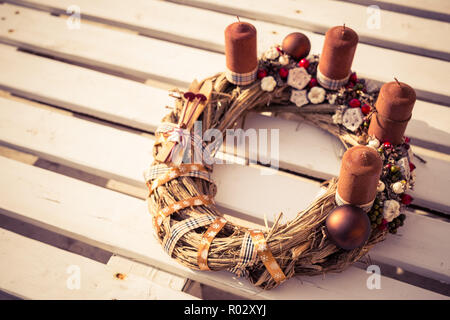Christmas home decoration with burning lights on white wooden background. Christmas wreath, moody seasonal background Stock Photo