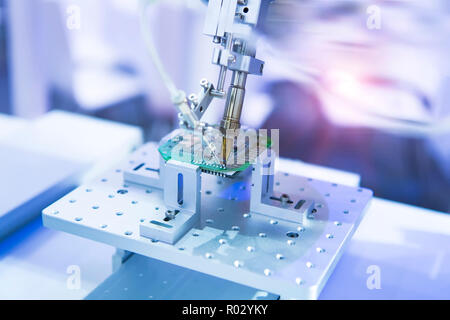 soldering iron tips of robotic system for automatic point soldering for printed and assembly electric circuit board ( PCB ) at factory Stock Photo