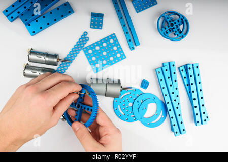 Man assembling metal robot kit. Above view of Making DIY set Stock Photo