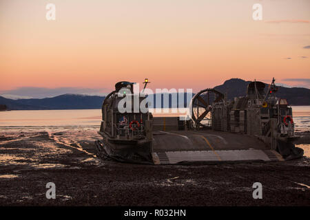 A landing craft air cushion rests on Alvund Beach after supporting an amphibious landing in during Trident Juncture 18 on Alvund Beach, Norway, Oct. 30, 2018. Trident Juncture provides a unique environment for the Marines and Sailors to rehearse their amphibious capabilities. The LCACs originated from USS New York (LPD 21) and showcased the ability of the Iwo Jima Amphibious Ready Group and the 24th Marine Expeditionary Unit to rapidly project combat power ashore. (U.S. Marine Corps photo by Lance Cpl. Margaret Gale) Stock Photo