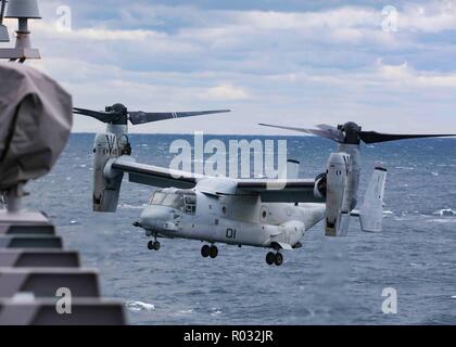 181027-N-HG389-0082 ATLANTIC OCEAN (Oct. 27, 2018) An MV-22B Osprey assigned to the “Black Knights” of Marine Medium Tiltrotor Squadron (VMM) 264 descends to the flight deck of amphibious transport dock ship USS Arlington (LPD 24) during the Carrier Strike Group (CSG) 4 composite training unit exercise (COMPTUEX). COMPTUEX is the final pre-deployment exercise that certifies the combined Kearsarge Amphibious Ready Group (ARG) and the 22nd Marine Expeditionary Unit’s (MEU) abilities to conduct military operations at sea and project power ashore through joint planning and execution of challenging Stock Photo