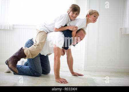 Father having fun while playing with his two young sons. Stock Photo