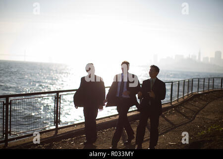Three businessmen walking on a pier. Stock Photo