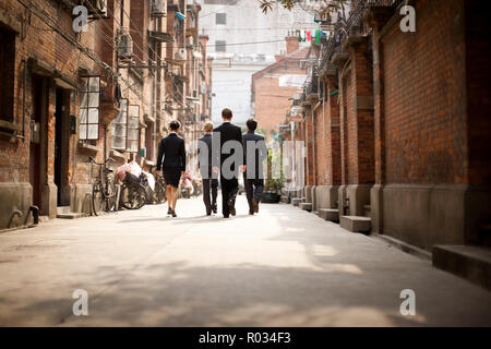 Four business colleagues walking side by side down a city street. Stock Photo