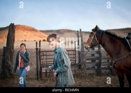 Two smiling teenagers in a stable at a ranch. Stock Photo