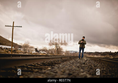 Man standing alone on train tracks. Stock Photo