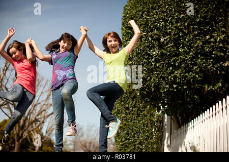 Three friends jumping in the street and having fun together. Stock Photo