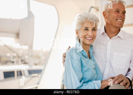 Smiling senior couple hold hands on the deck of a boat. Stock Photo