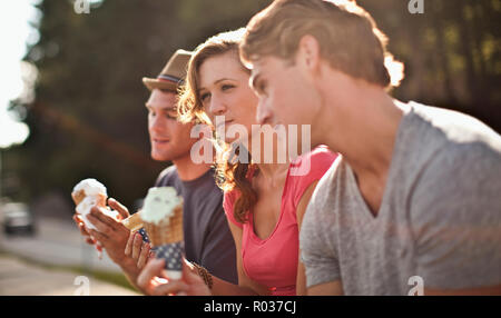 Three friends enjoying ice-cream together. Stock Photo