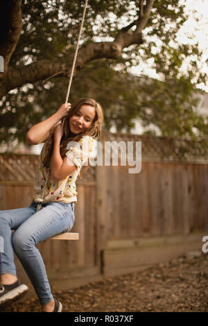 Teenage girl on a rope swing. Stock Photo