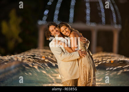 Portrait of a happy mid adult couple dancing by a fountain. Stock Photo