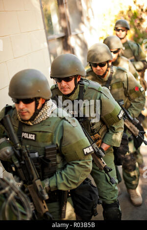 Team of armed military police holding guns while running through a ...