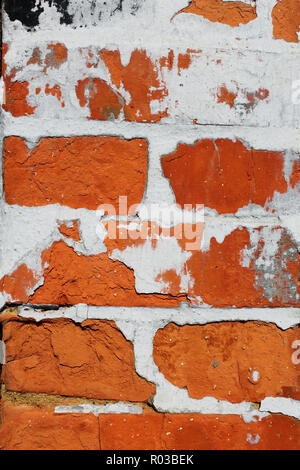 Fragment of old brick wall with concrete covering shelled close up Stock Photo
