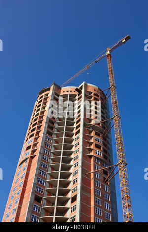 Building cranes on the construction of dwelling skyscraper. Serene sunny day Stock Photo