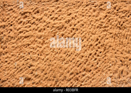 Fragment of the old wall covered with painted plaster embossed Stock Photo