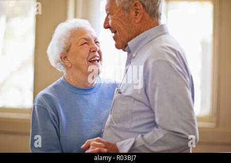 Happy senior couple dancing together in a room. Stock Photo