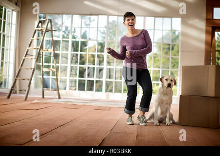 Happy young woman celebrating moving into a new house. Stock Photo