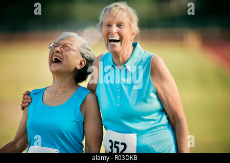 Two happy senior women laughing after competing in an athletic event. Stock Photo