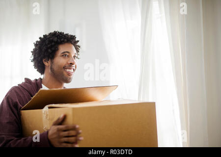 Happy young man moving into a new home. Stock Photo