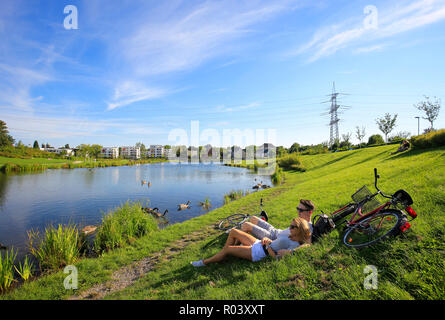 Essen, Ruhr area, Germany, urban development project Niederfeldsee, young couple lies in the meadow Stock Photo