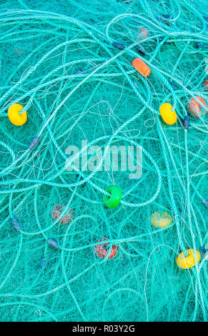 turquoise-colored fishing net with colorful floats Stock Photo