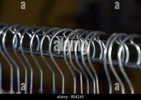 plastic hangers reflected background, metal clothes hangers on clothes rail macro shot Stock Photo