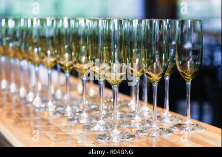 Empty white wine glasses ordered in symmetry on a countertop. Stock Photo