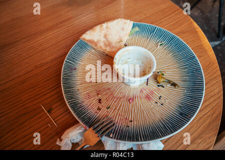 Table after eating with empty plate and remains on it, shot with copyspace Stock Photo