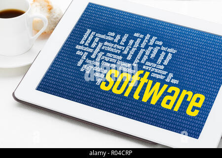 computer software word cloud on zero one binary background - digital tablet with a cup of coffee Stock Photo