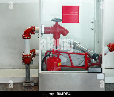 Emergency security kit - fire hydrant, water supply valve, fire extinguisher in a glass box. Indoor safety.