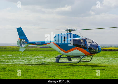Eurocopter EC120 Colibri G-HEHE helicopter of HE Group Ltd landing at former Leysdown Airfield, Kent, UK for centenary of first British flight Stock Photo
