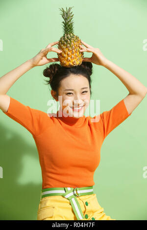 Young woman holding a pineapple Stock Photo