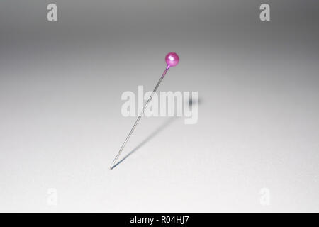 purple pin sticked in white background Stock Photo