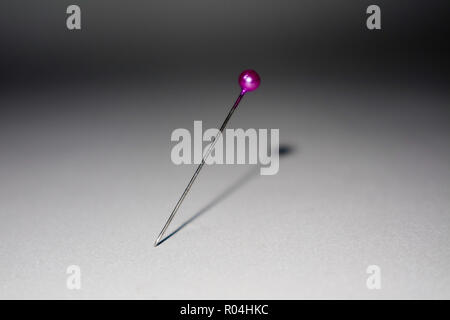 purple pin sticked in white background Stock Photo