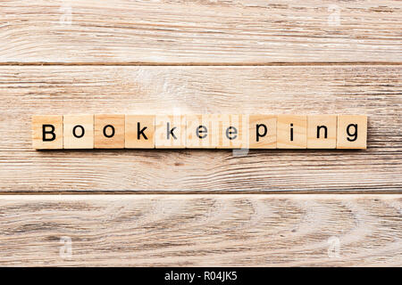 bookkeeping word written on wood block. bookkeeping text on table, concept. Stock Photo