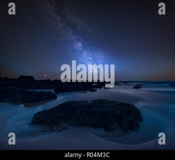 Stunning vibrant Milky Way composite image over landscape of Freshwater West beach on Pembrokeshire Coast in Wales Stock Photo