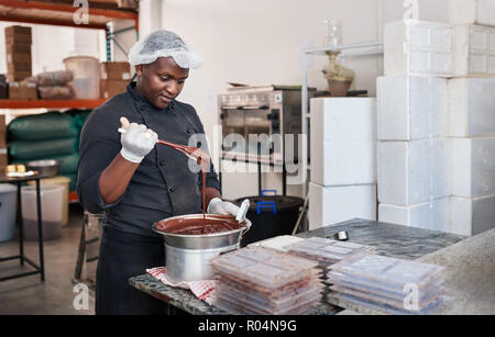 Worker using a bain marie to melt chocolate Stock Photo