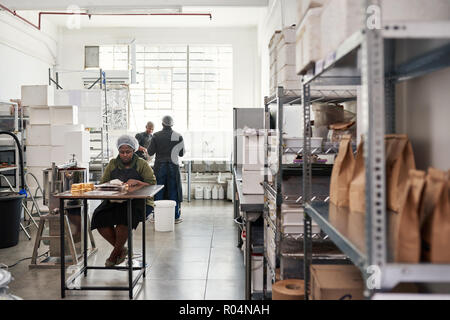 People at work together in an artisanal chocolate making factory Stock Photo