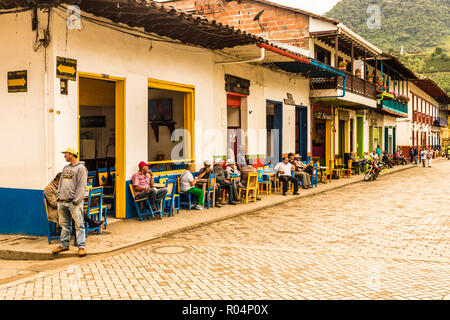 Local people socialising on the main square, with its preserved, colourful, colonial buildings, Jardin, Colombia, South America Stock Photo