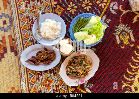 Traditional Thai spicy lunch with chicken,pork and sticky rice on a rush mat Stock Photo
