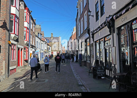 A view up Church Street towards 199 steps in Whitby, North Yorkshire, England, UK on a bright autumn day with a blue, cloudless sky. Stock Photo