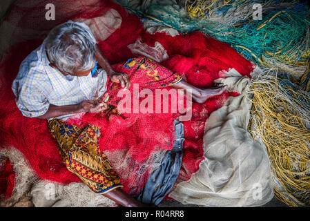 Fisherman mending net at Kappil Beach, Varkala, Kerala, India, Asia Stock Photo