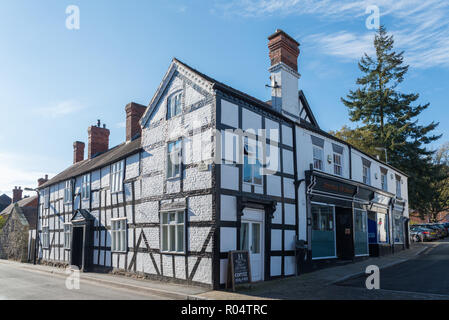 Large black and white timber-framed building with fake painted brick wall in Church Stretton, Shropshire Stock Photo