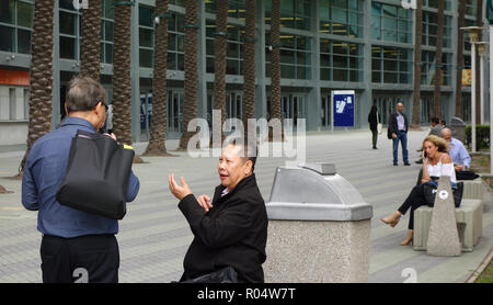 Two conference attendees (Asian men) having an animated discussion outside the Anaheim Convention Center Stock Photo