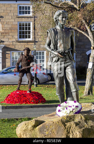 Great Ayton village,The North York Moors National Park, North Yorkshire, England, United Kingdom. 2nd November 2018. Knitted poppies around Willow sculpture of First World War soldier in Grear Ayton village, North Yorkshire on a clear and frosty morning. The sculpture is in remembrance to the men and women of the village who served during The Great War. Off the 260 who went off to war, only 50 returned. Great Ayton was the childhood home of Captain James Cook. Sculpture in foreground is a young James Cook. Credit: ALAN DAWSON/Alamy Live News Stock Photo