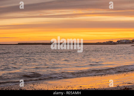 Lyme Regis, Dorset, UK. 2nd November 2018.  UK Weather:  Sunset at Lyme Regis at the end of a beautiful Autumn day.  The sky glows orange over the Cobb Harbour as the sun sets. Credit: Celia McMahon/Alamy Live News Stock Photo