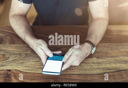 man sitting at table using a smartphone Stock Photo